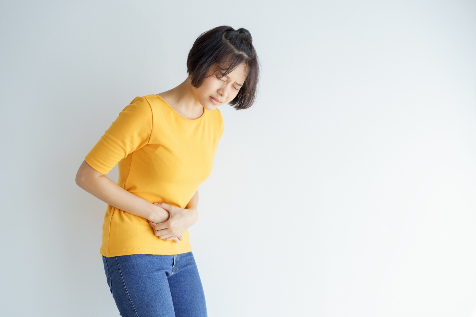 변비로 배가 더부룩해 배를 감싸 쥔 여성